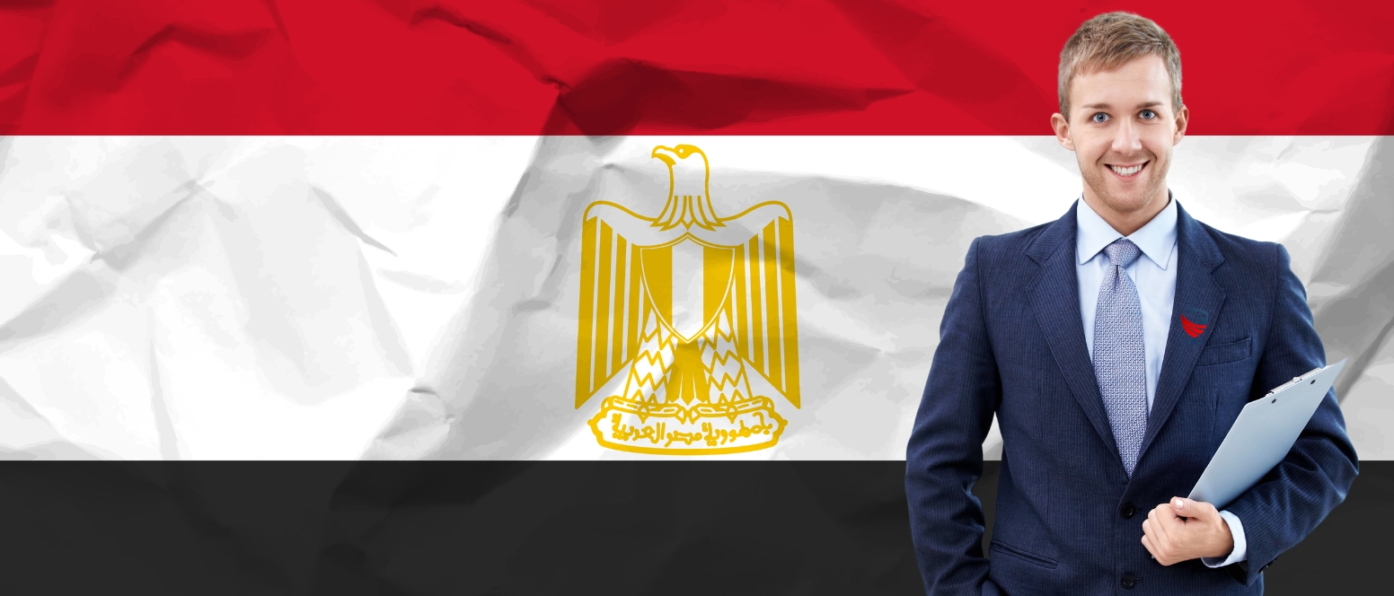 A professional male with a visa to visit Egypt is standing next to the national flag of Egypt.