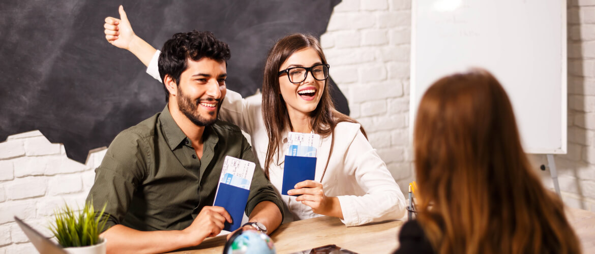 A man and woman sitting at a table with a book, discussing UAE visit visa requirements.